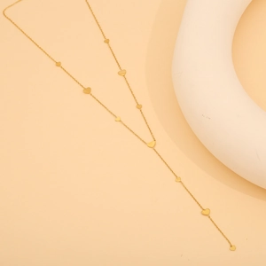 Detailed macro view of delicate golden heart pendants on a fine titanium steel chain