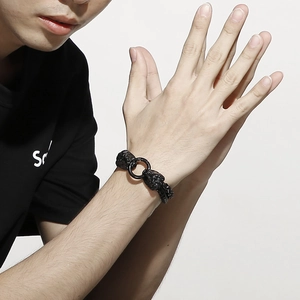 Detail of matte black lion head double chain bracelet for men with woven texture