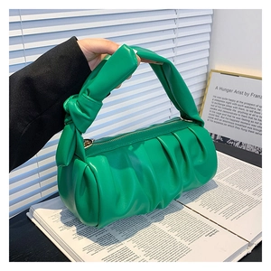 Close-up of green pleated cloud bag with PU leather texture and stylish knot handle