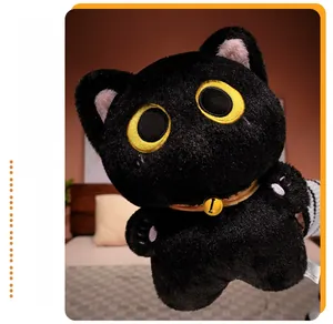 Detail of black cat plush toy with yellow eyes and pink paw embroidery in a cozy bedroom