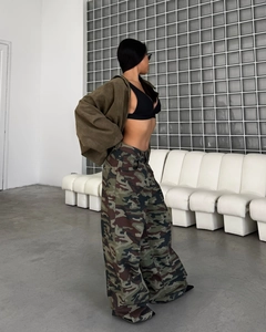 Détail du pantalon cargo à imprimé camouflage et coupe large dans un studio moderne