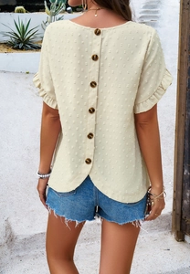 Detail view of ruffle sleeves and back button design on polka dot women's beige top