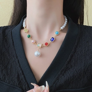 Colorful gemstone and pearl necklace with baroque pendant on elegant model