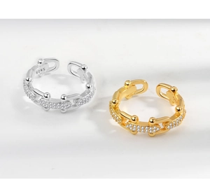 Detail of silver and gold chain rings with small diamonds and S925 hallmark stamp
