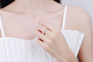 Detail shot of a 925 silver minimalist band ring with a single sparkling stone on a finger