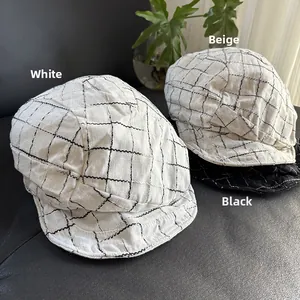 Three plaid linen newsboy hats in white, beige, and black colors displayed on a flat surface