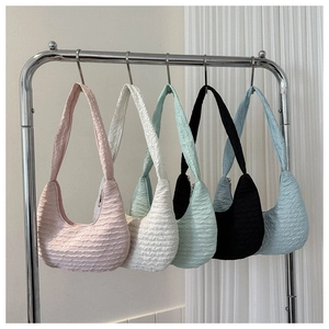 Close-up of stylish textured dumpling bags in five pastel colors hanging on display