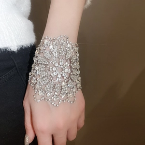 Nahaufnahme des funkelnden silbernen Armreifs mit floralem Diamantbesatz am Handgelenk