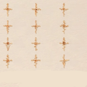 Detailed grid view of 12 gold cross pendants featuring unique monthly birth flowers