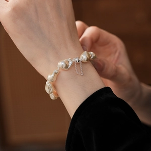 Macro view of baroque pearls with magnetic clasp worn on wrist for an elegant style