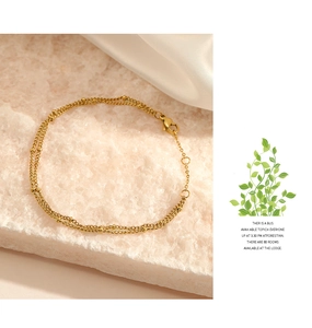 Detailed macro of gold double-layer beaded bracelet with lobster clasp and extender