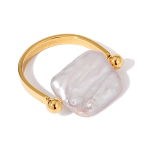 Minimalist gold titanium steel ring featuring a square freshwater baroque pearl on white background