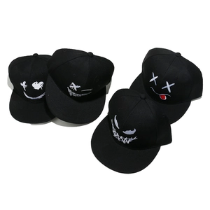 Dettaglio di quattro cappellini snapback hip-hop neri con ricami graffiti bianchi