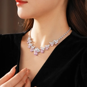 Gros plan sur un collier en argent avec pendentif floral en zircons roses et blancs