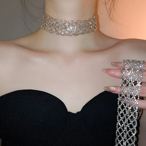 Gros plan d'un ras-de-cou large argenté avec motif de grille évidé et strass étincelants