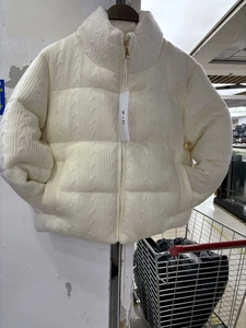 Detail view of cream white knitted jacket featuring stand collar and zipper closure