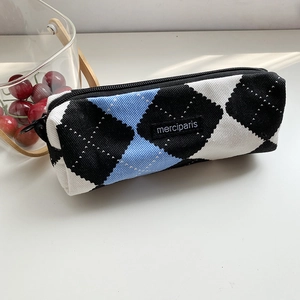 Primer plano de estuche de lona acolchada con diseño tricolor y detalle de cremallera