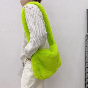Close-up of fluffy fluorescent green faux fur crossbody bag with matching wide strap