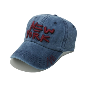 Detail of red NEW YORK embroidery on vintage navy blue washed denim baseball cap