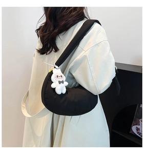 Sac à bandoulière demi-lune noir minimaliste avec un joli porte-clés lapin blanc