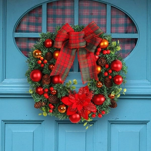 Christmas wreath with red bows, pine cones, and gold ornaments on a blue door