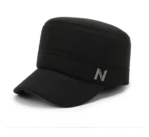 Detail of black military cap with silver metal N logo and textured fabric finish