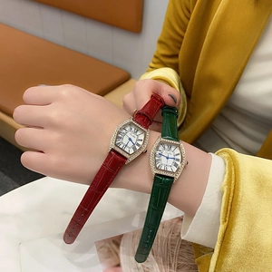 Close-up of elegant tonneau-shaped watches with leather straps and rhinestone bezel