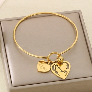 Detail of gold heart charms featuring mother and child silhouette with Love engraving