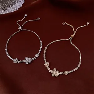 Luxurious gold and silver zircon flower bracelets on elegant brown satin background