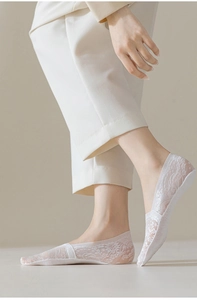 Close-up of white floral jacquard lace socks with breathable cotton sole on model feet