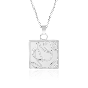 Macro detail of a silver square necklace pendant with embossed floral rose pattern