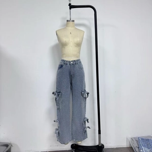 Detail of light blue denim cargo pants with large pockets and adjustable drawstring hem