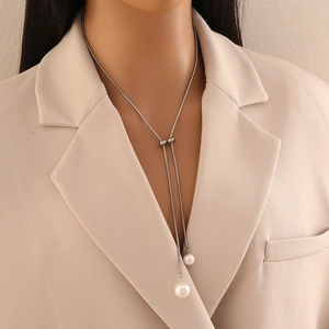 Elegant long silver Y-shaped necklace with pearl pendants shown on a professional model
