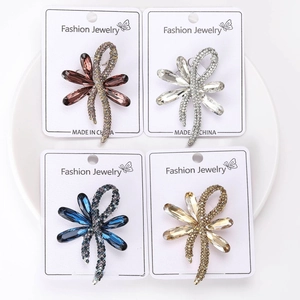 Detailed view of four colorful rhinestone dragonfly brooches on fashion display cards