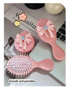 Rosa Schleife Massage-Haarbürsten-Set mit Klappspiegel-Kamm für Kinder auf dem Tisch