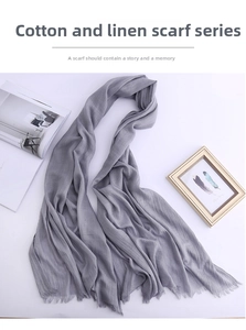 Detailed view of light grey cotton linen scarf with natural frayed tassel edge textures