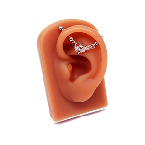Barbell industriel argenté avec pendentif renard en cristal sur un modèle d'oreille