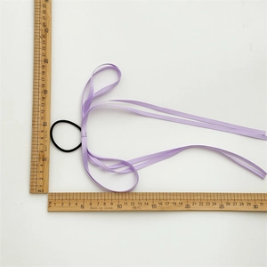 Size reference of purple satin bow hair tie with measuring ruler showing 20cm length