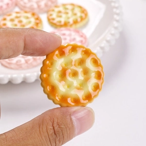 Macro shot of a golden resin macaron model held by hand showing detailed wavy edges