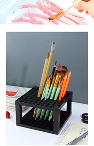 Detail of 96-slot black plastic art brush holder organized on a clean desk