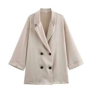 Détail du tissu texturé beige avec boutons noirs à double boutonnage et étiquette S