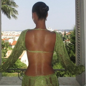 Detail of green crochet knit dress showing the sexy backless design and sheer texture