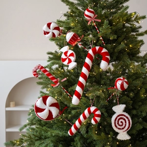 Red and white glittery candy cane and lollipop ornaments hanging on a decorated Christmas tree