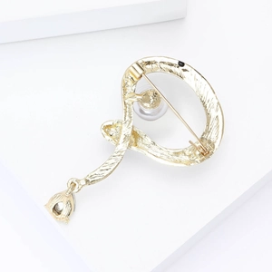 Detail of golden snake enamel brooch with pearl and water drop crystal pendant