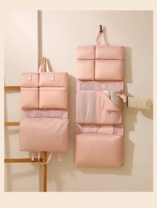 Detail of light pink hanging toiletry bag with zipper mesh pockets for travel storage