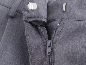 Gros plan du pantalon de costume gris en sergé avec crochet métallique et fermeture éclair