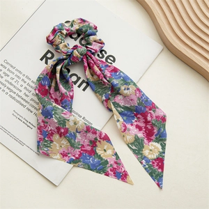 Floral print scrunchie with long ribbons displayed on an open magazine page