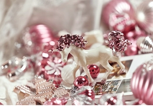 Close-up of pink and silver Christmas ornaments with a glittery white unicorn figurine