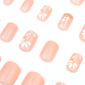 Faux ongles courts carrés rose nude avec pointes French blanches et motifs fleurs pailletées