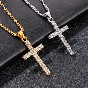 Gros plan de pendentifs croix or et argent avec cristaux brillants sur fond noir
